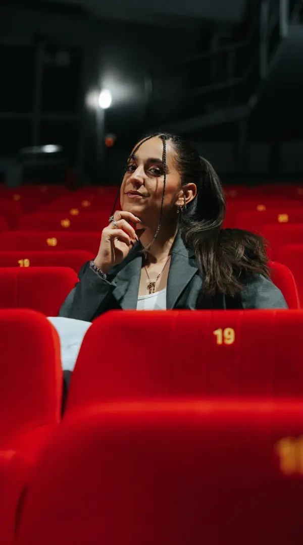 Julia Ortola assise dans les fauteuils rouges du Théâtre de Suresnes Jean Vilar